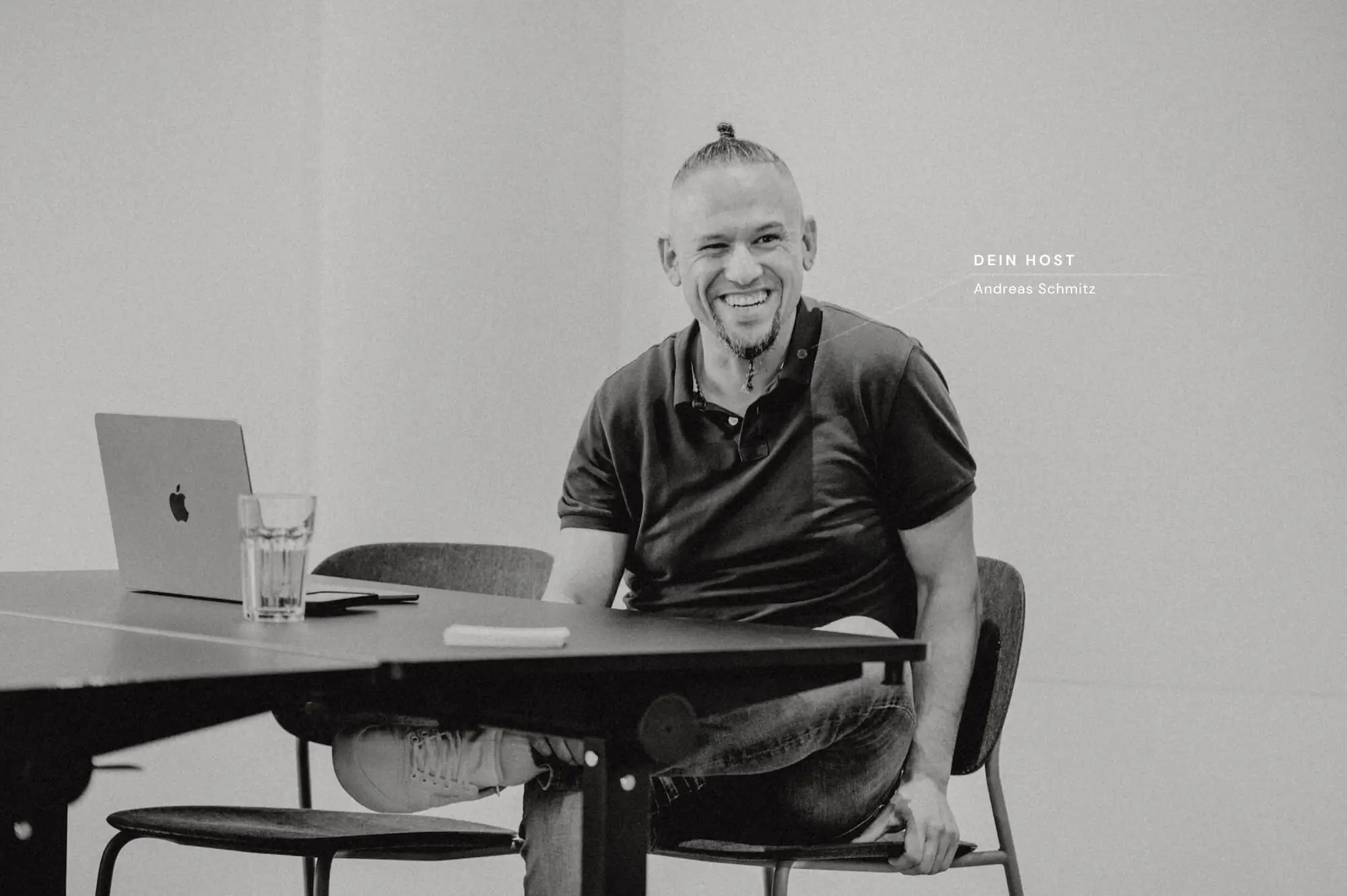 Andreas Schmitz, Host von BENE Mastermind, am Tisch mit MacBook.